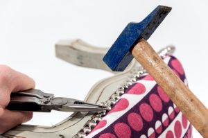 Step 7: Next attach the upholstery tack trim by bending it around the edges of the foot stool to cover the line of staples. Use a hammer and watch out for your fingers!