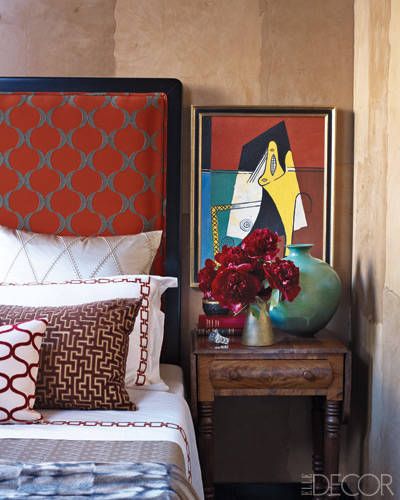 A bedside table can double up as a tiny 'gallery' space. (elledecor.com)